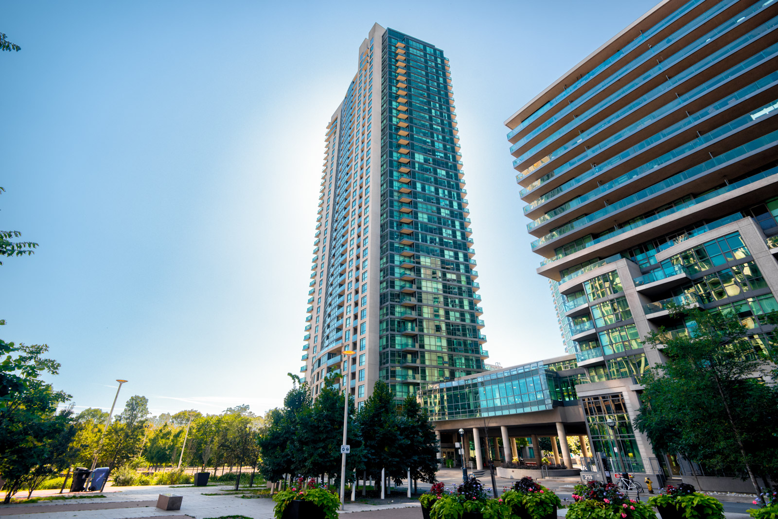 Looking up at Neptune II condos, a 38-story rectangular building of blue glass and gray stone.