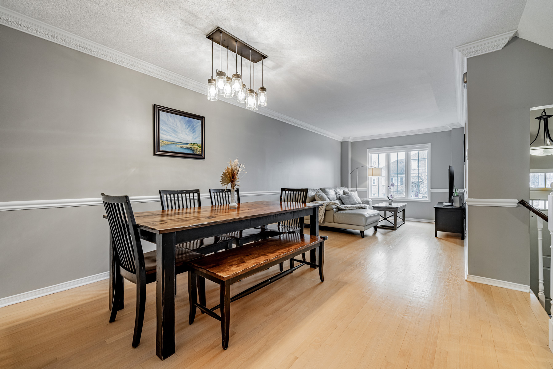 77 Schouten Cres dining room with chandelier and living room with large windows.