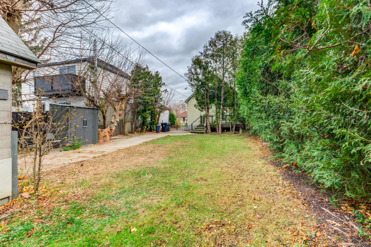 Huge backyard with trees and grass.