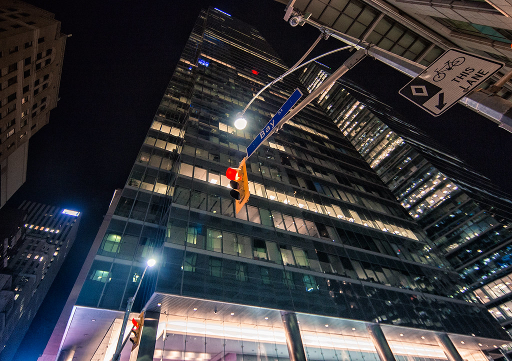 Looking up at building on Bay Street at night.