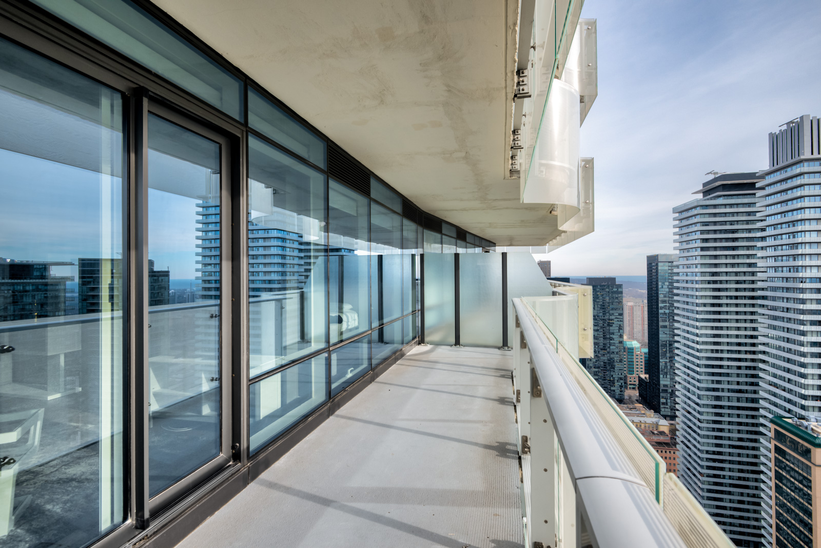 Daytime view of balcony with distant view of CN Tower from One Bloor Condos.