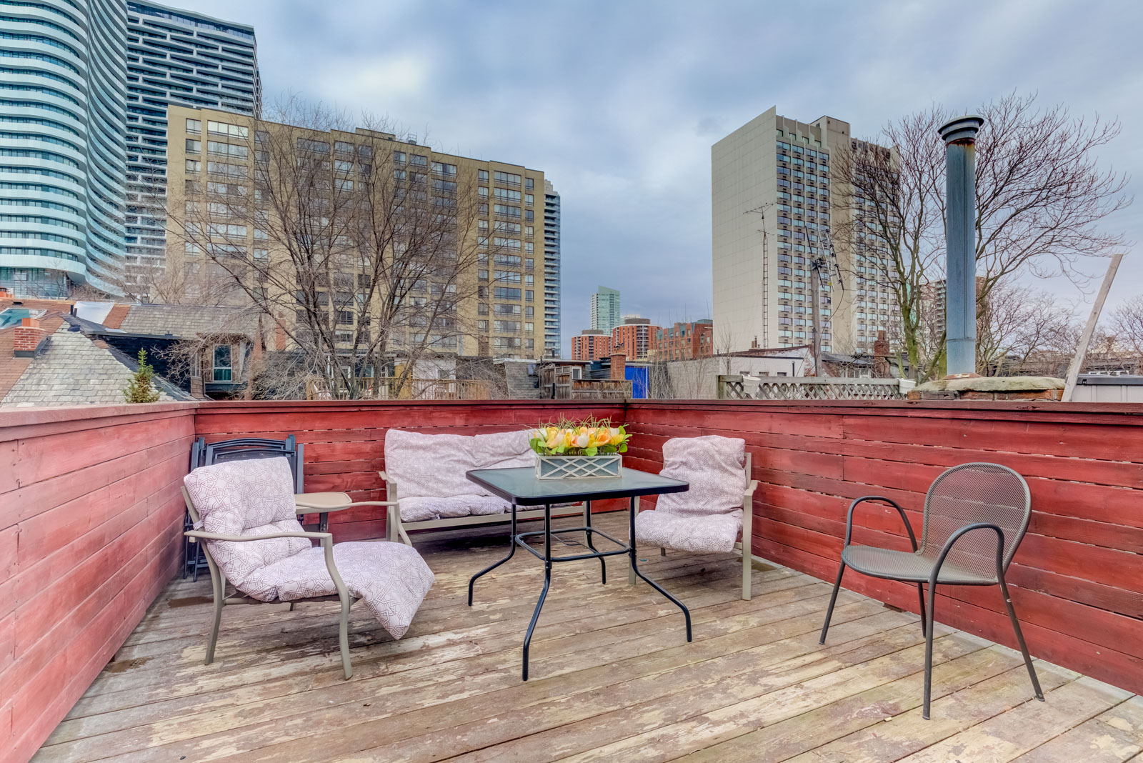 Outdoor wooden deck with chairs and tables on third floor of 120 McGill St.