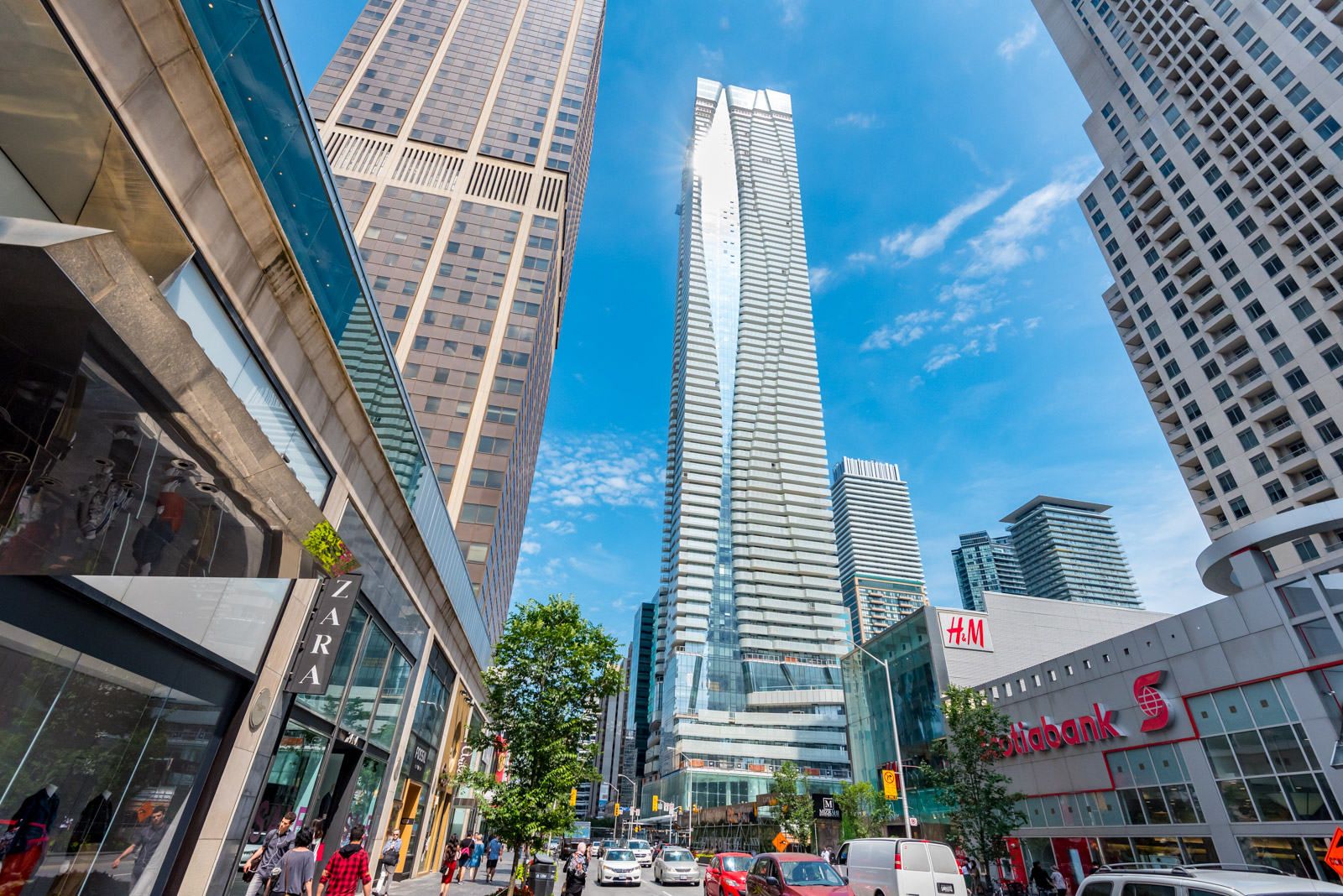 Streets, buildings and people near 1 Bloor St E Toronto.