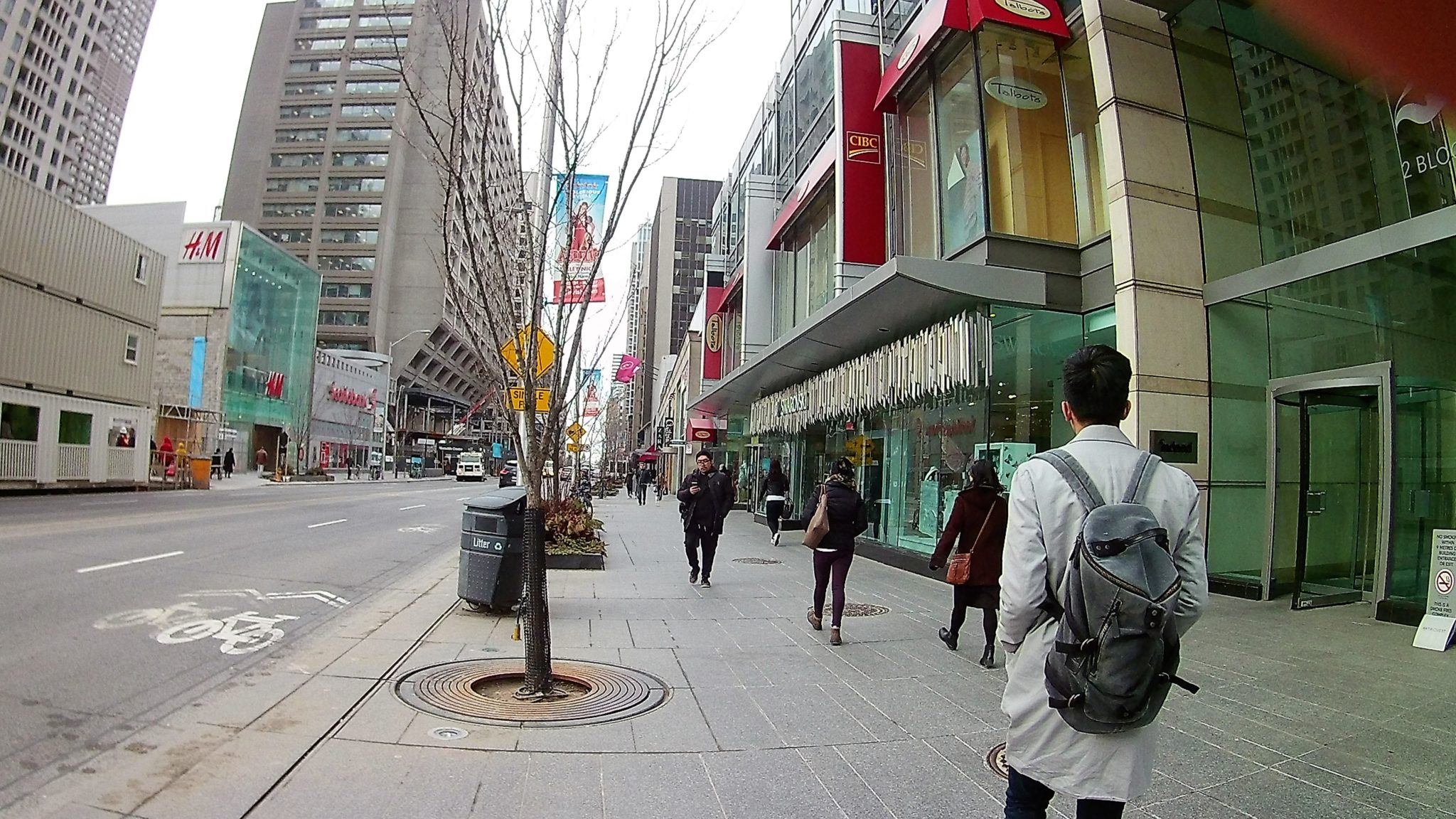 Photo of Bloor street showing people, banks, shops, and buildings.