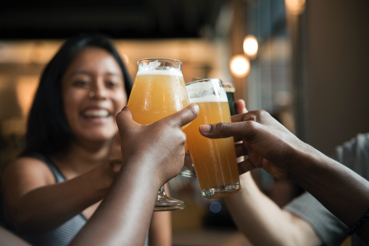 Young people clinking glasses at bar. 