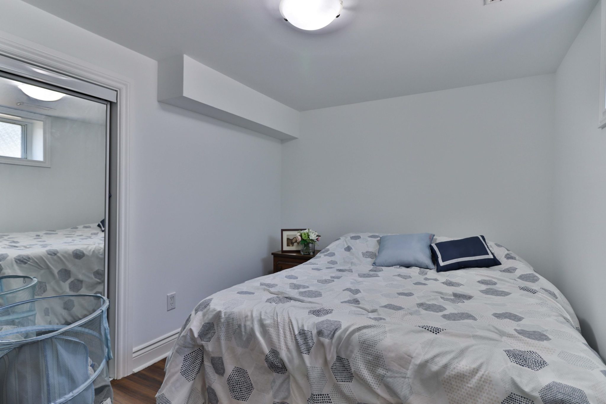 117 Phillip Ave basement bedroom with large bed and mirror door closet.