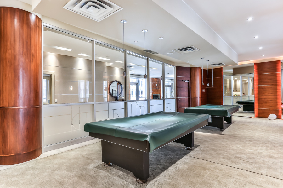 Empty condo rec centre with billiards tables.