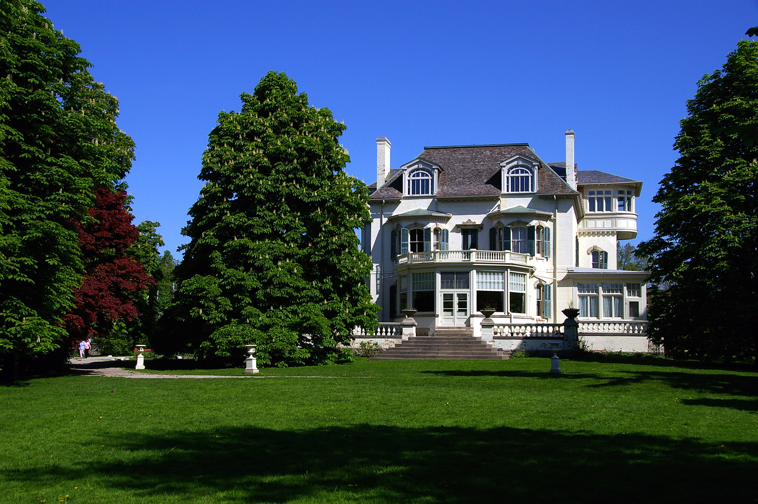 Spadina House in Toronto, a giant mansion with tall trees in foreground.