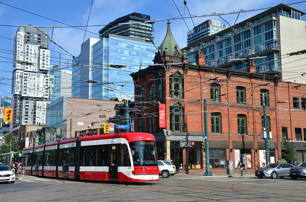 Red TTC street car turning on Queen St W in Toronto.