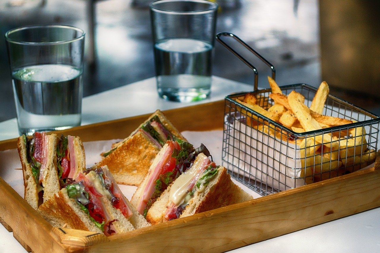 Fast food tray with club sandwich and French fries.