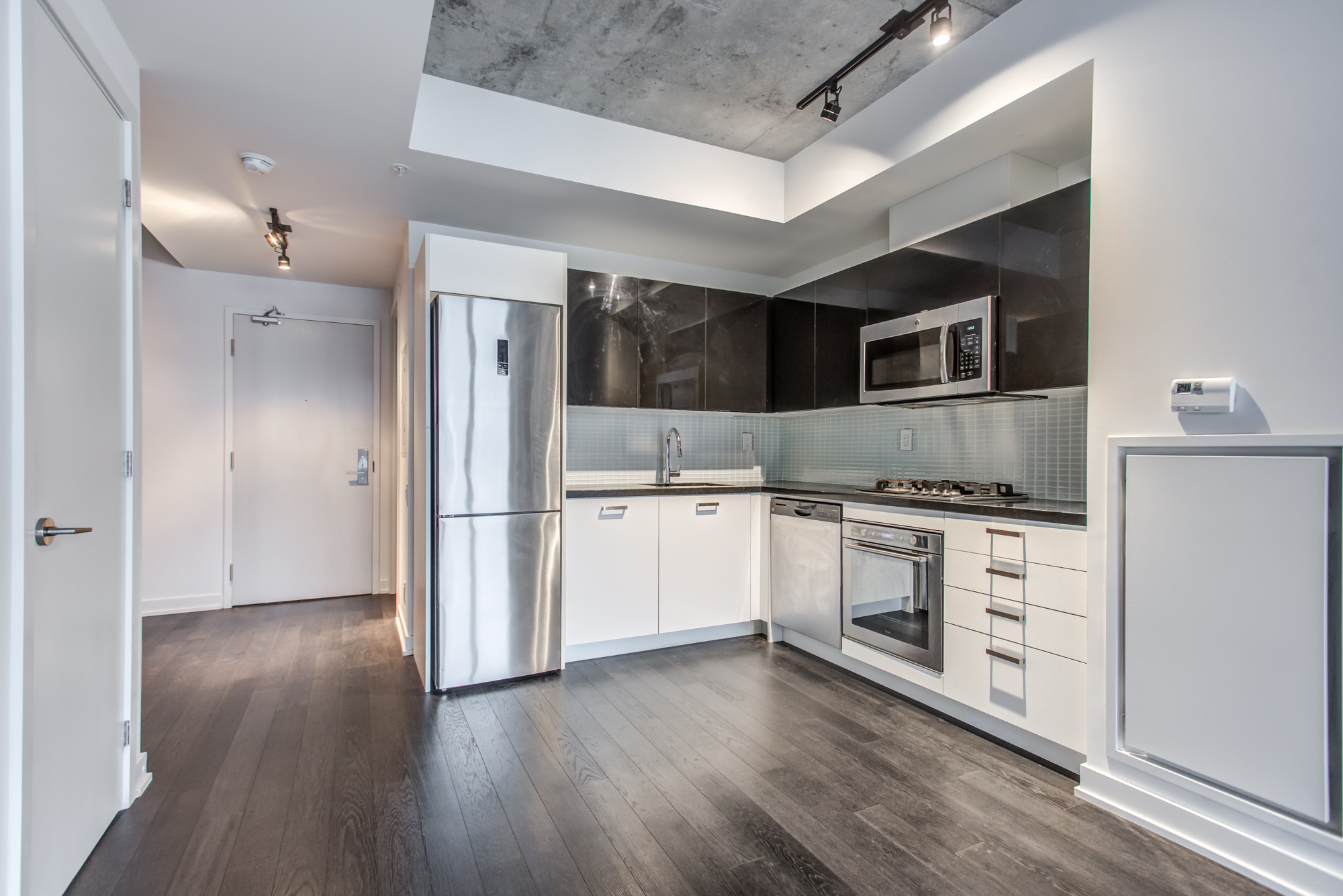 Condo with laminate floors and exposed concrete at 39 Brant St Unit 918, Brant Park Lofts, Queen West.