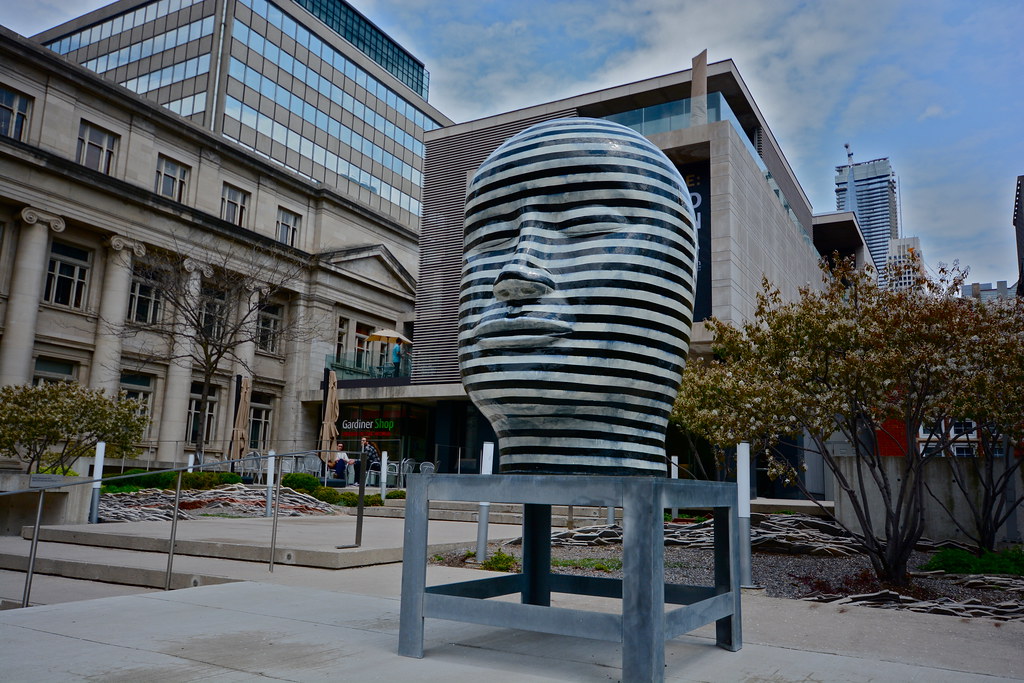 Black and silver striped sculpture of human head outside Gardiner Museum on Bloor West.