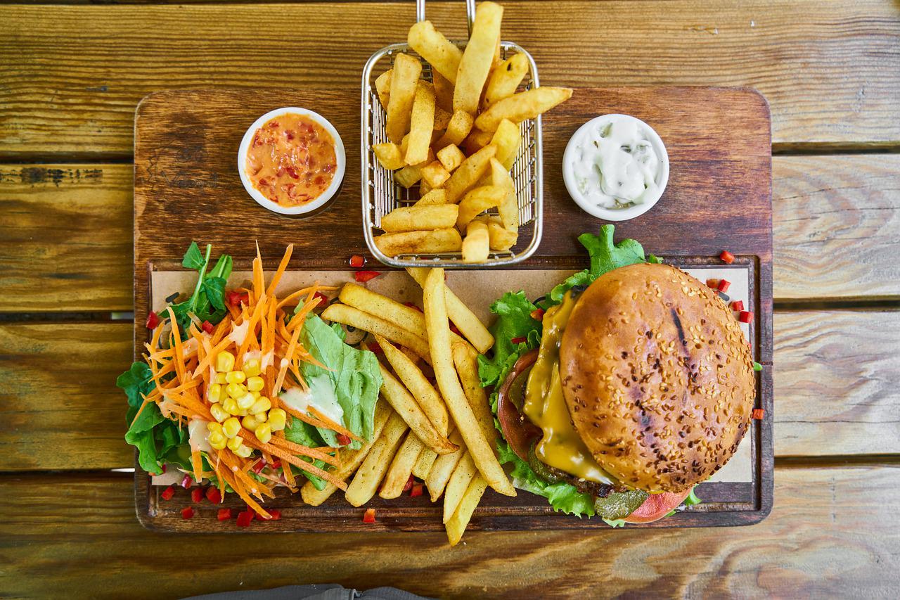 Plate of fast food with burger, fries & salad.