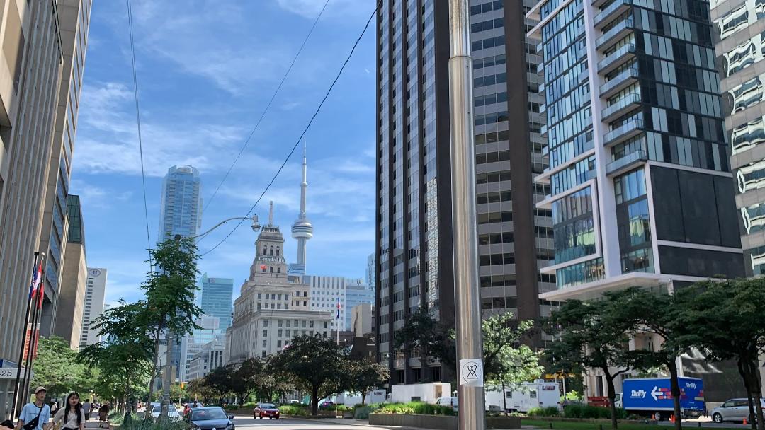 Street view of condos, people, Canada Life Building and CN Tower from Yonge and Dundas.