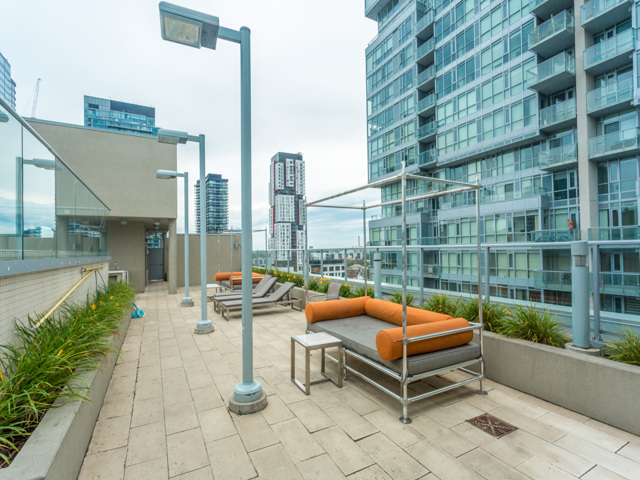 View of rooftop lounge with lamps and buildings