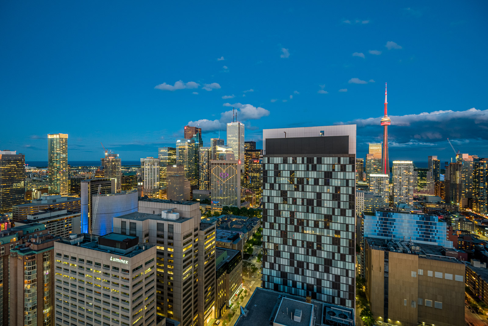 Bright lights of Toronto and CN Tower at night seen from balcony of 488 University Ave.