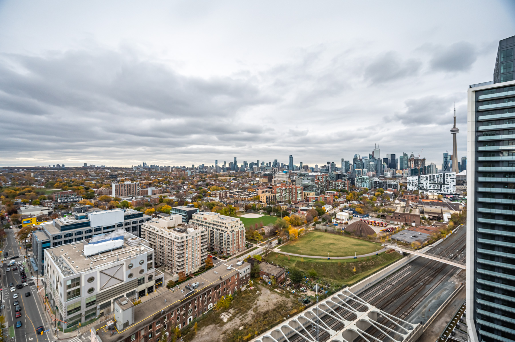 Balcony view of Toronto parks, railroads, buildings, bridges and CN Tower.