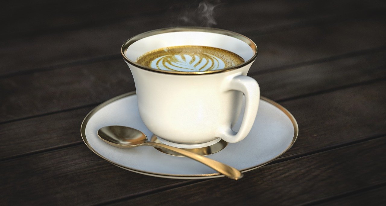 White cup and saucer with steaming coffee.