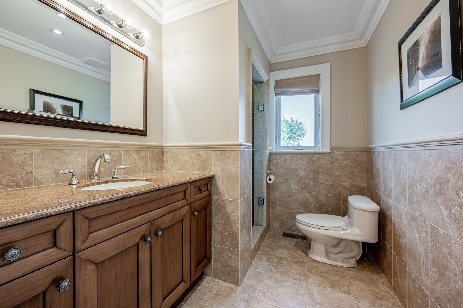 3 piece bathroom with vanity, cabinets, mirror and shower.