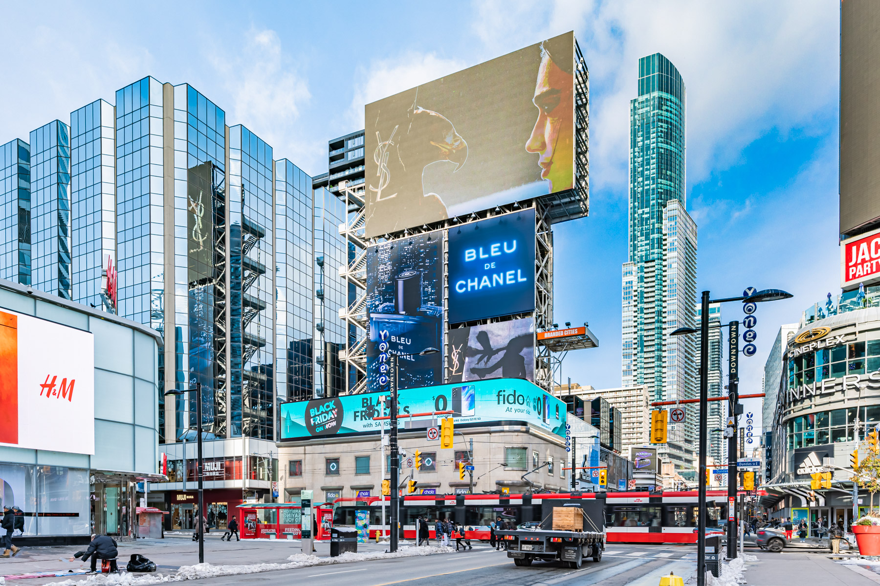 Pedestrians, transit and vehicles along busy Yonge and Dundas Square in Toronto.