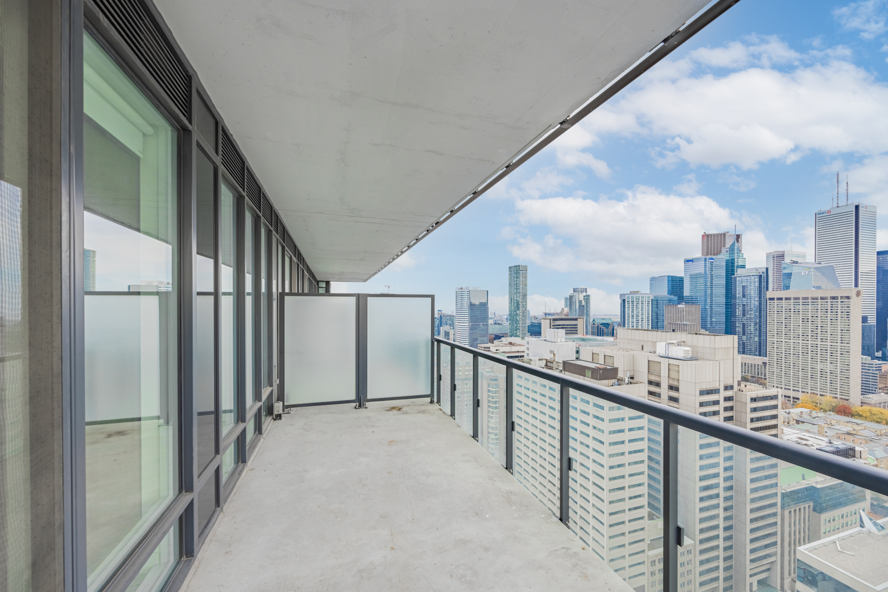 Balcony with glass panels and opaque divider.