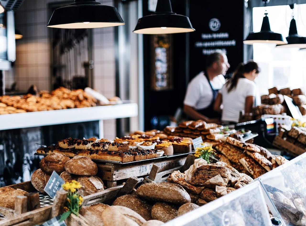 Bakery with baskets of buns and pastries in foreground.