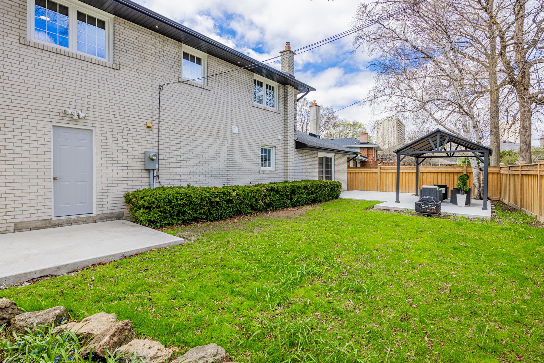 3 Logwood Court large backyard with green lawn, fence and shrubs.