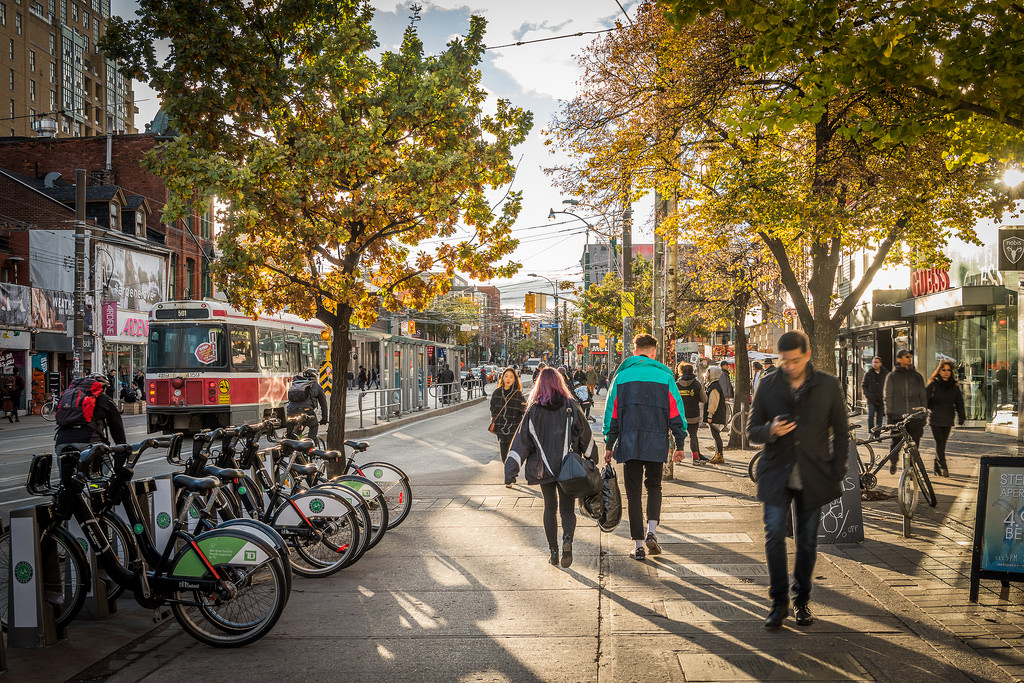 People, streetcars and bicycles along queen st w