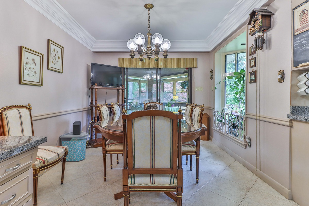 Eat-in kitchen with fancy dining table, chairs and chandelier.