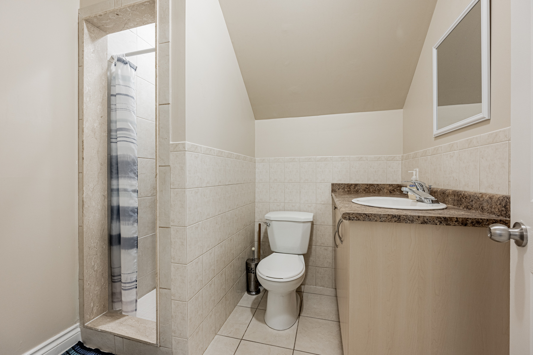 This 3-piece bath has porcelain floors, a large vanity and a walk-in shower. Basement bathroom with porcelain floors, vanity and shower.