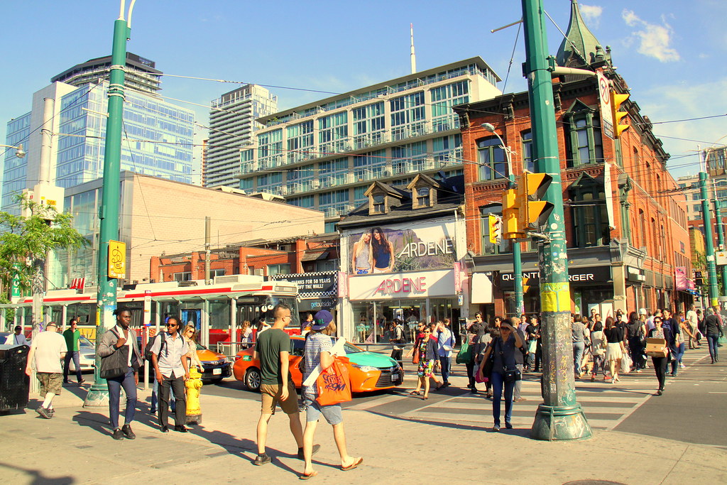 People, streetcars and storefronts along Toronto's Entertainment District. 