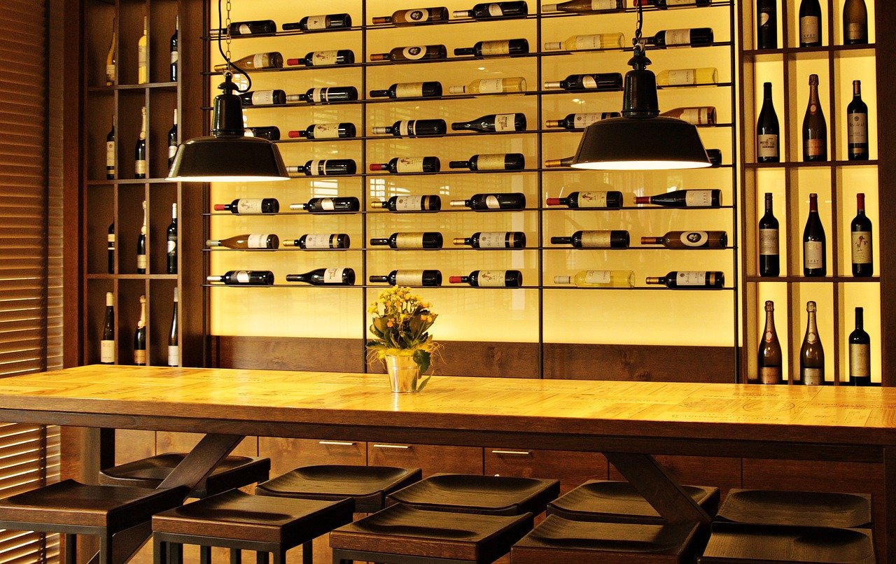 Wine bottles stacked neatly behind bar.