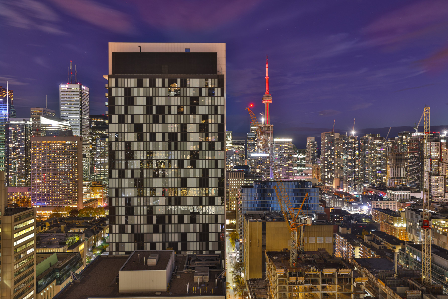 View of CN Tower glowing red from 488 University Ave Unit 2710 balcony.