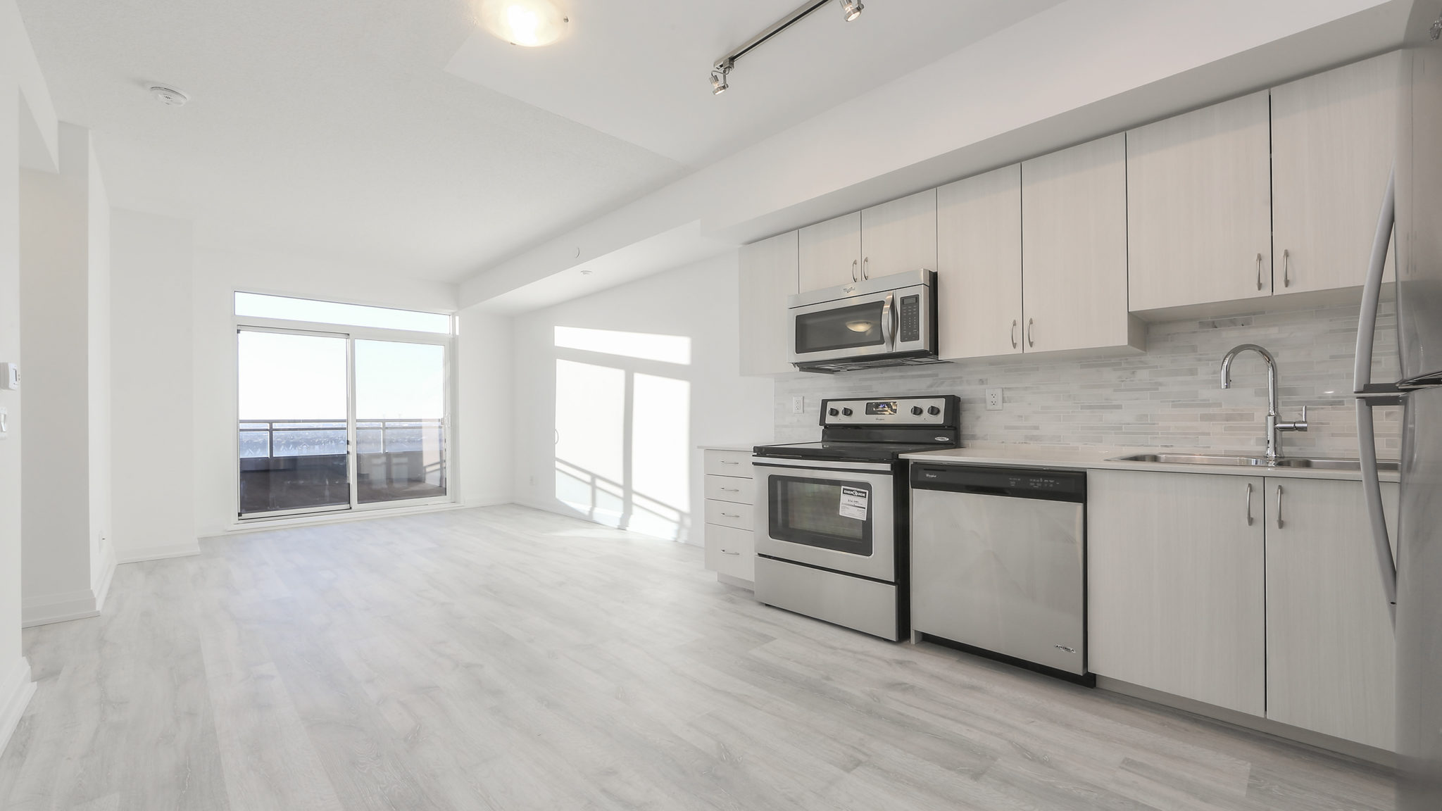 Another image showing the condo's open-concept style and lovely design. Here we see the kitchen and dining room.
