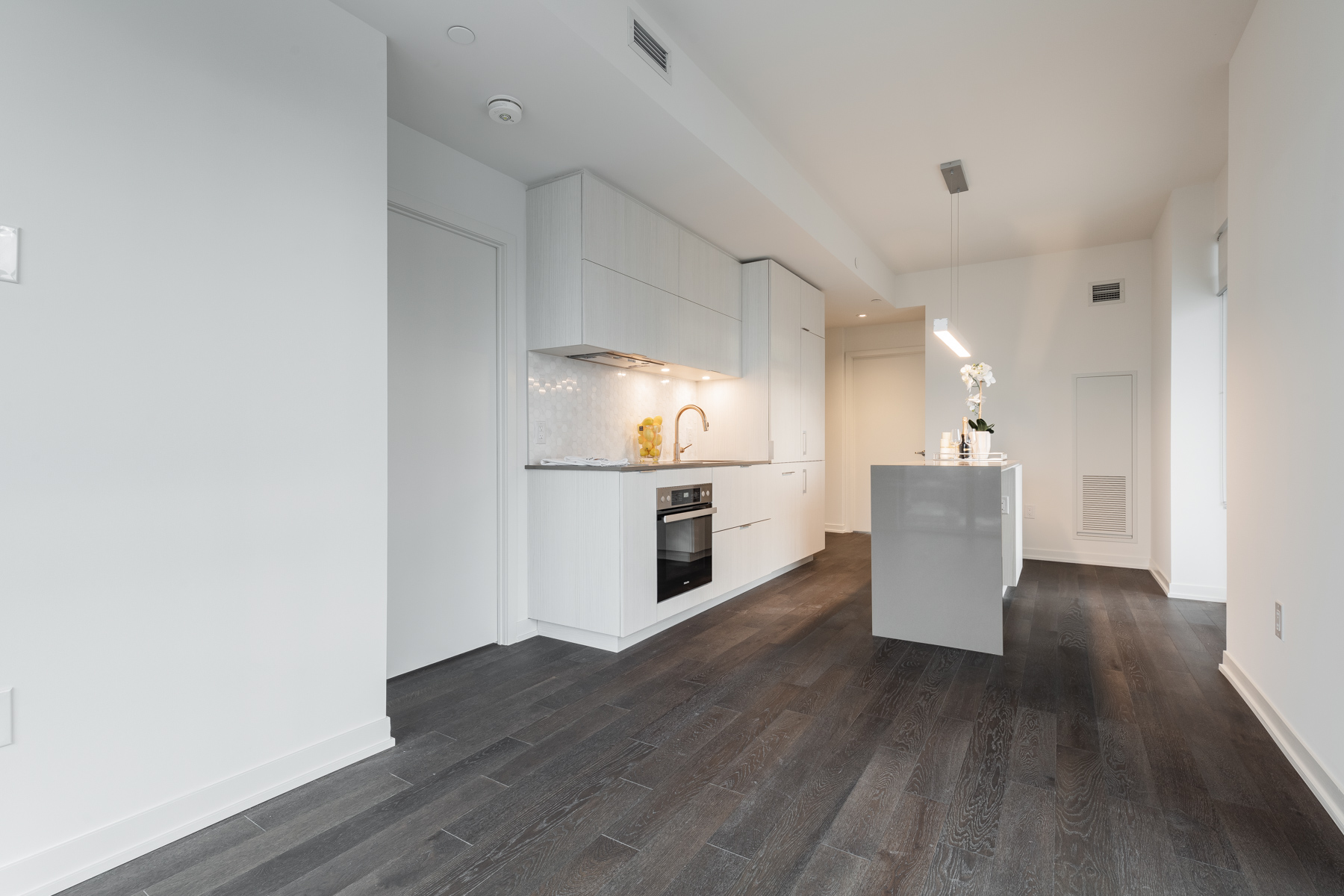 Dark hardwood floors and gray walls of 20 Richardson St dining room and kitchen.