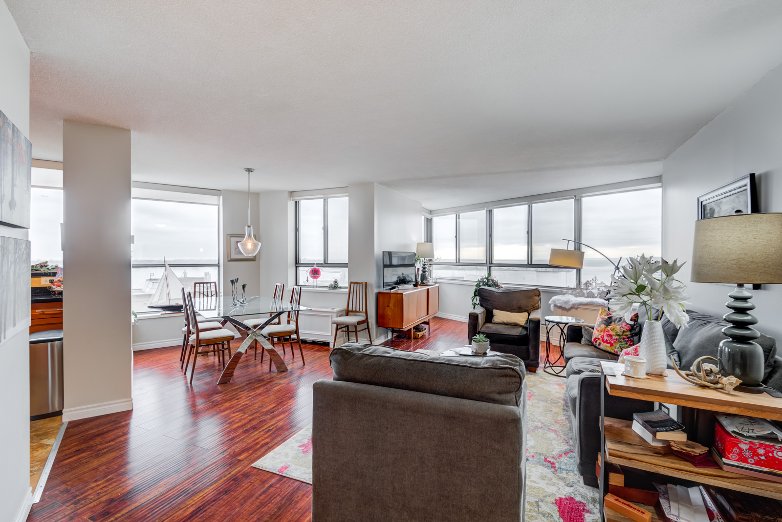 260 Queens Quay W Unit 1202 living and dining room with red laminate floors and huge windows.
