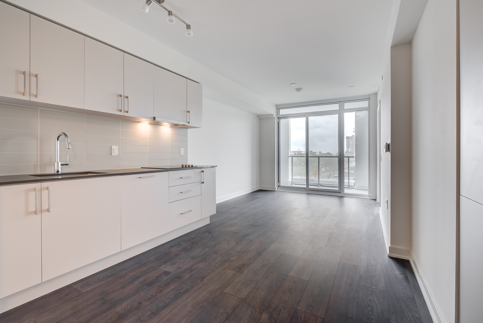 Empty living room, dining room and kitchen of 27 Bathurst Unit 308.