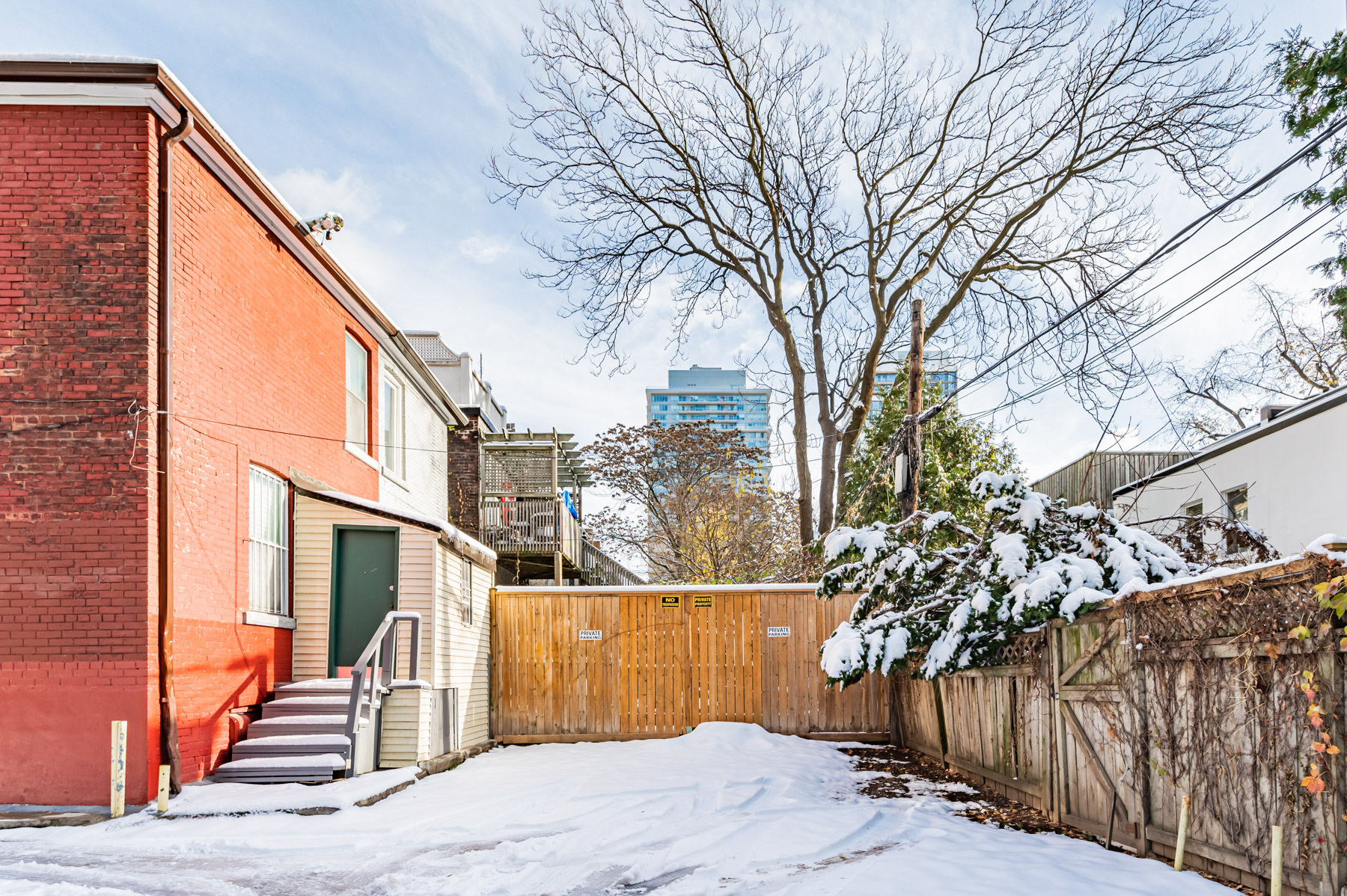 House backyard covered in snow with room for private parking.