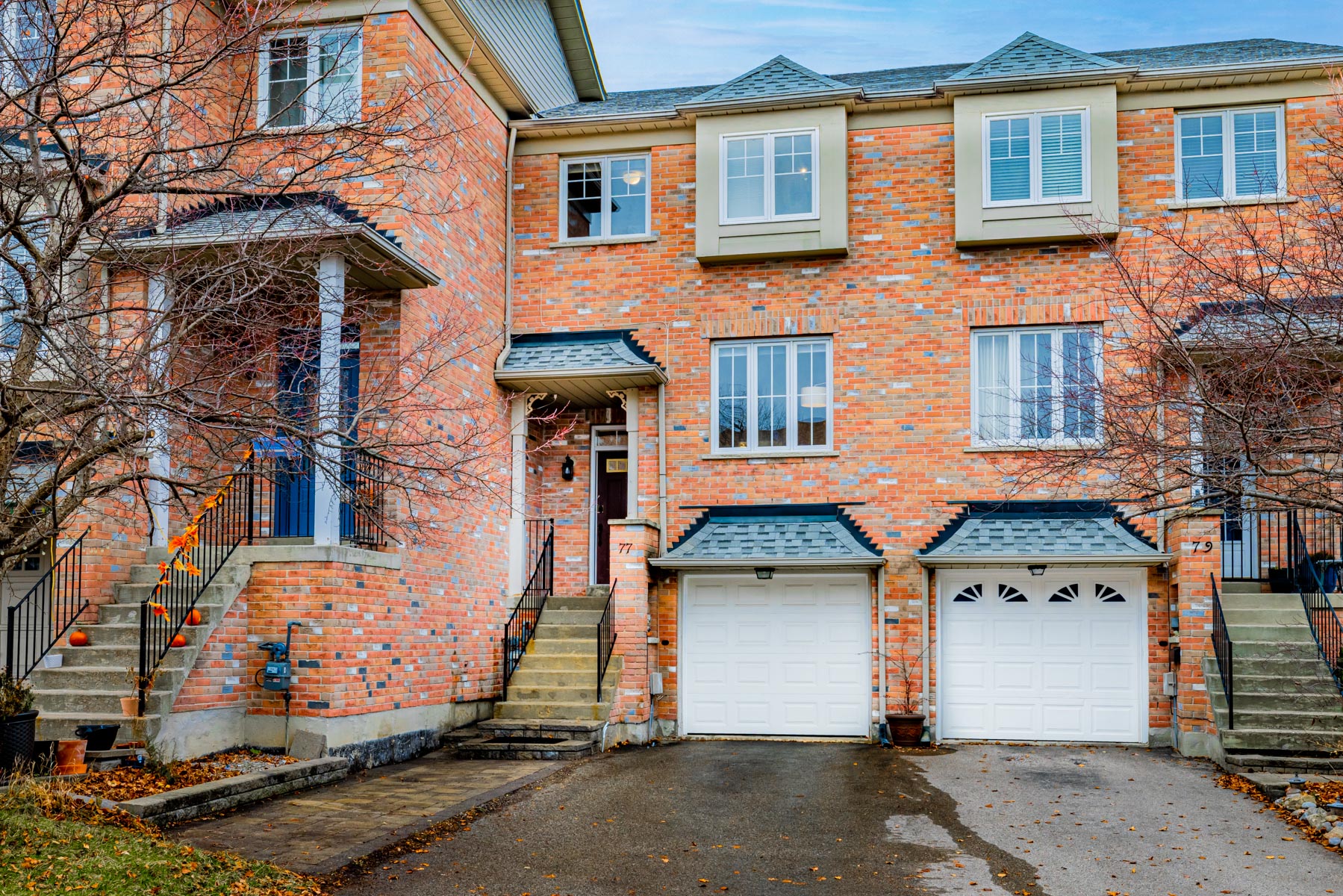 Red brick facade of 77 Schouten Cres, a 2-storey townhouse.