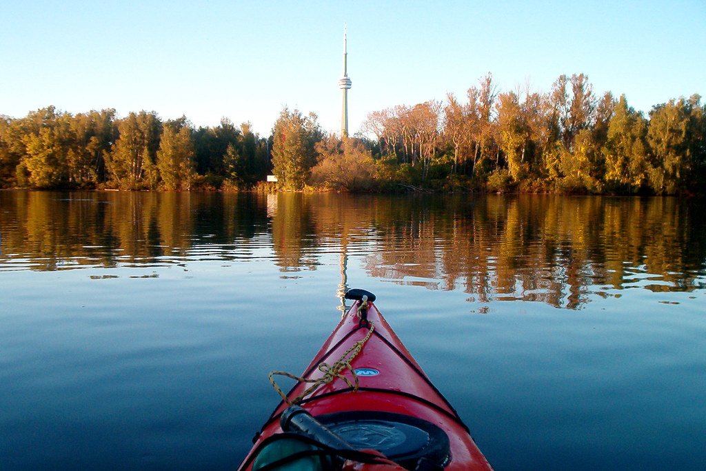 Red kayak in foreground with CN Tower in background.