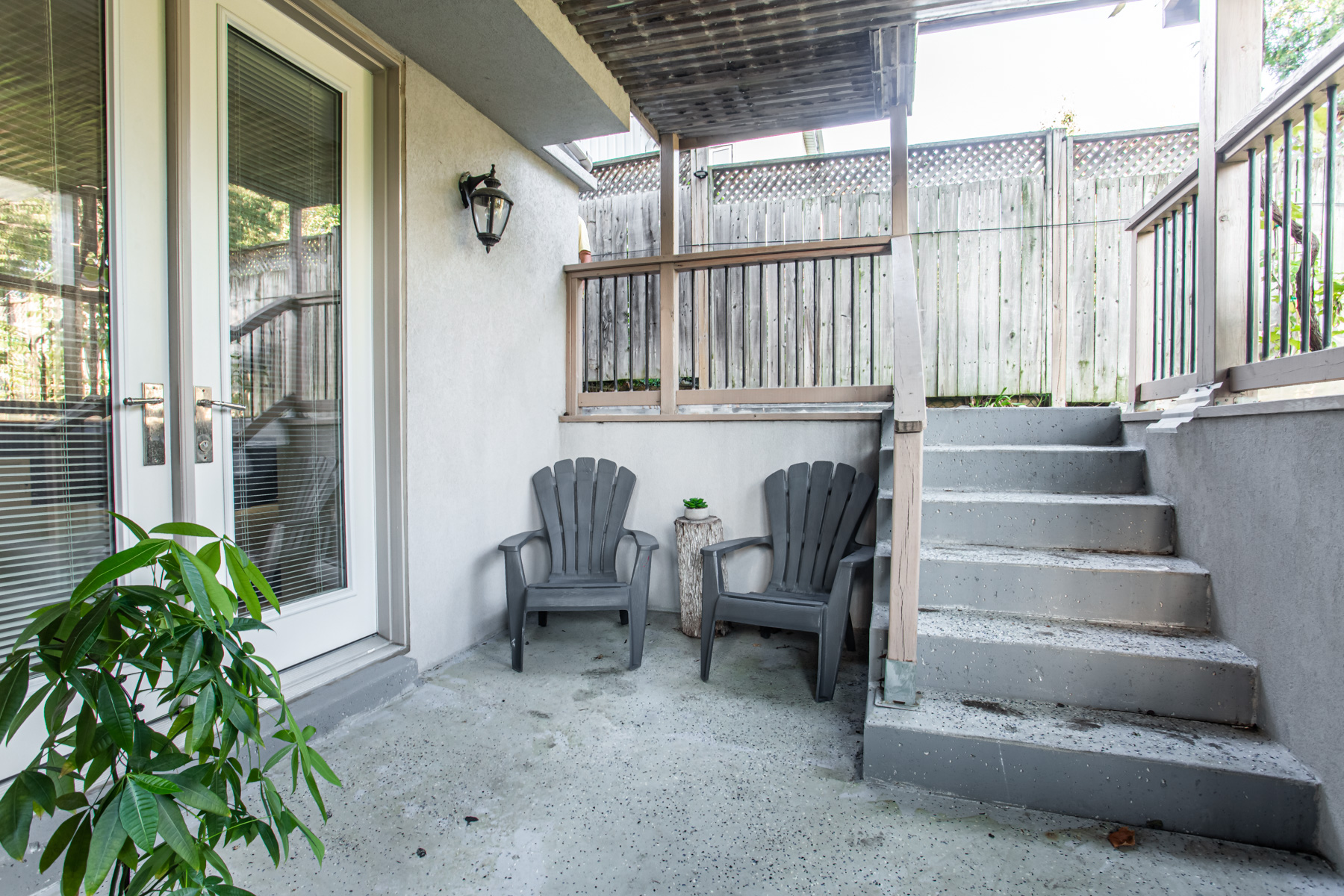 Patio of 741 Glencairn Ave with two chairs, plant and concrete steps.