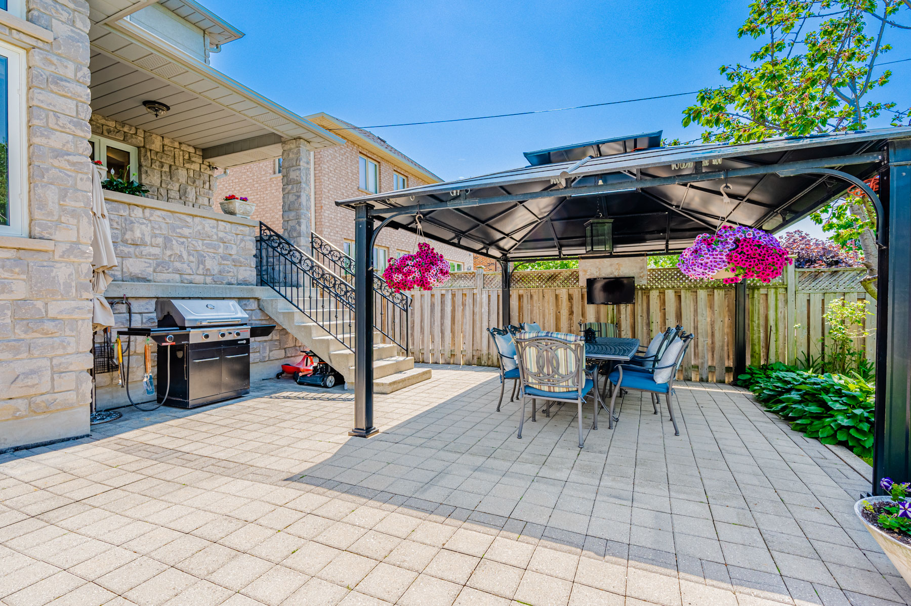 12 Highland Hill backyard with steel pavilion, BBQ equipment, table and chairs.