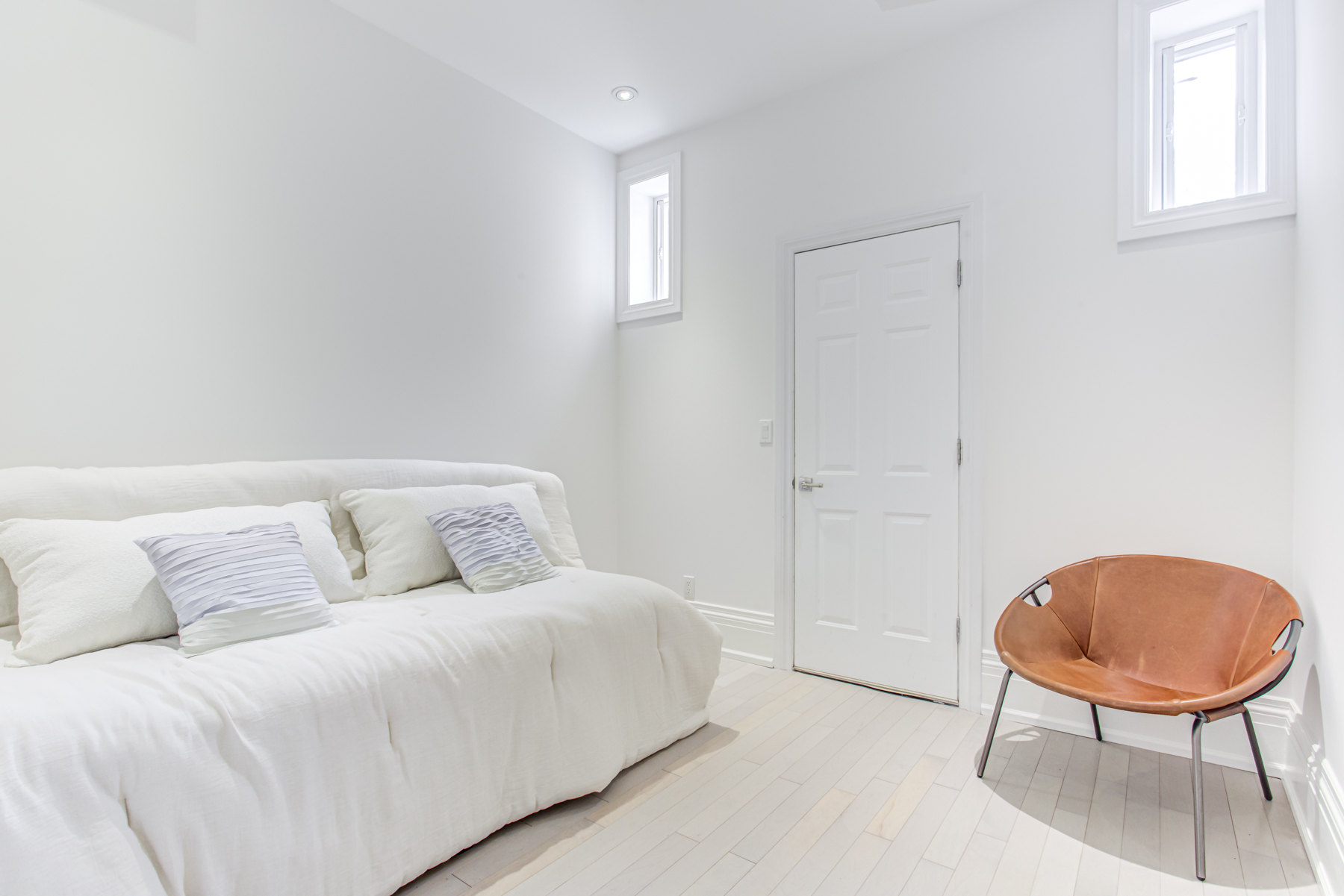 741 Glencairn Ave nanny suite with bed, chair and hardwood floors.