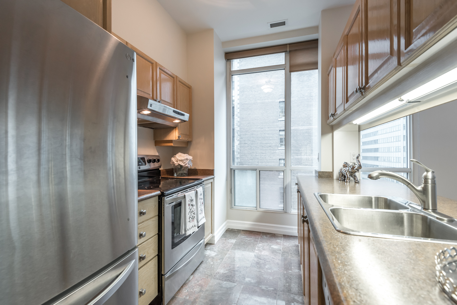 We see the kitchen from another angle. Most noteworthy is the tall windows and natural light.