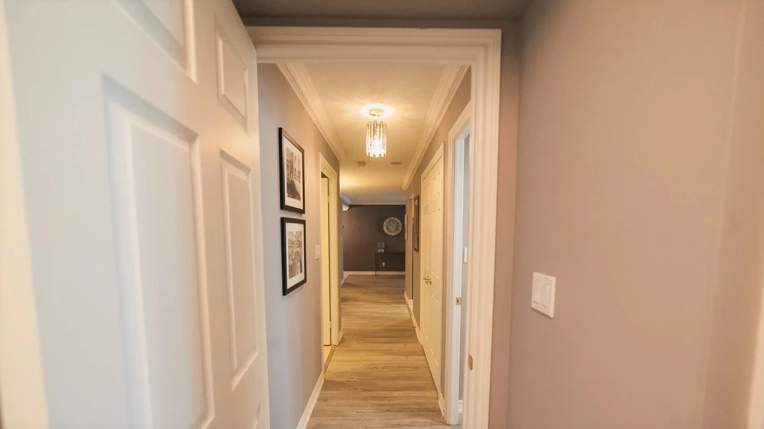 168 Simcoe foyer with new laminate floors and framed photos on walls.