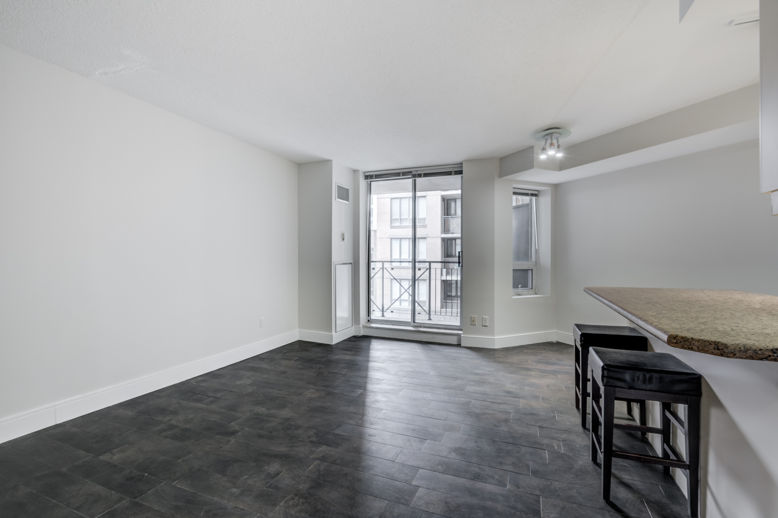 Dark brown laminate floors of 140 Simcoe St E Unit 921 living and dining room.