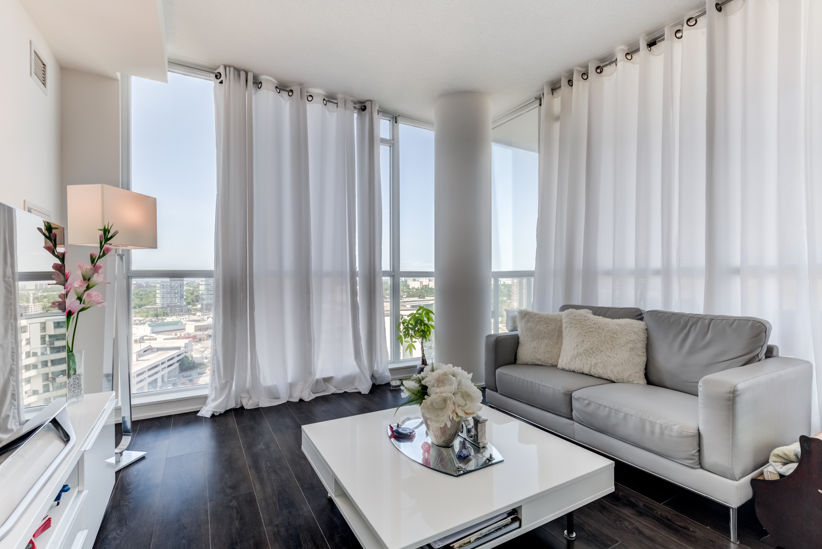 Dark laminate floors shining with light from windows at 62 Forest Manor Rd Unit 1803, Toronto.