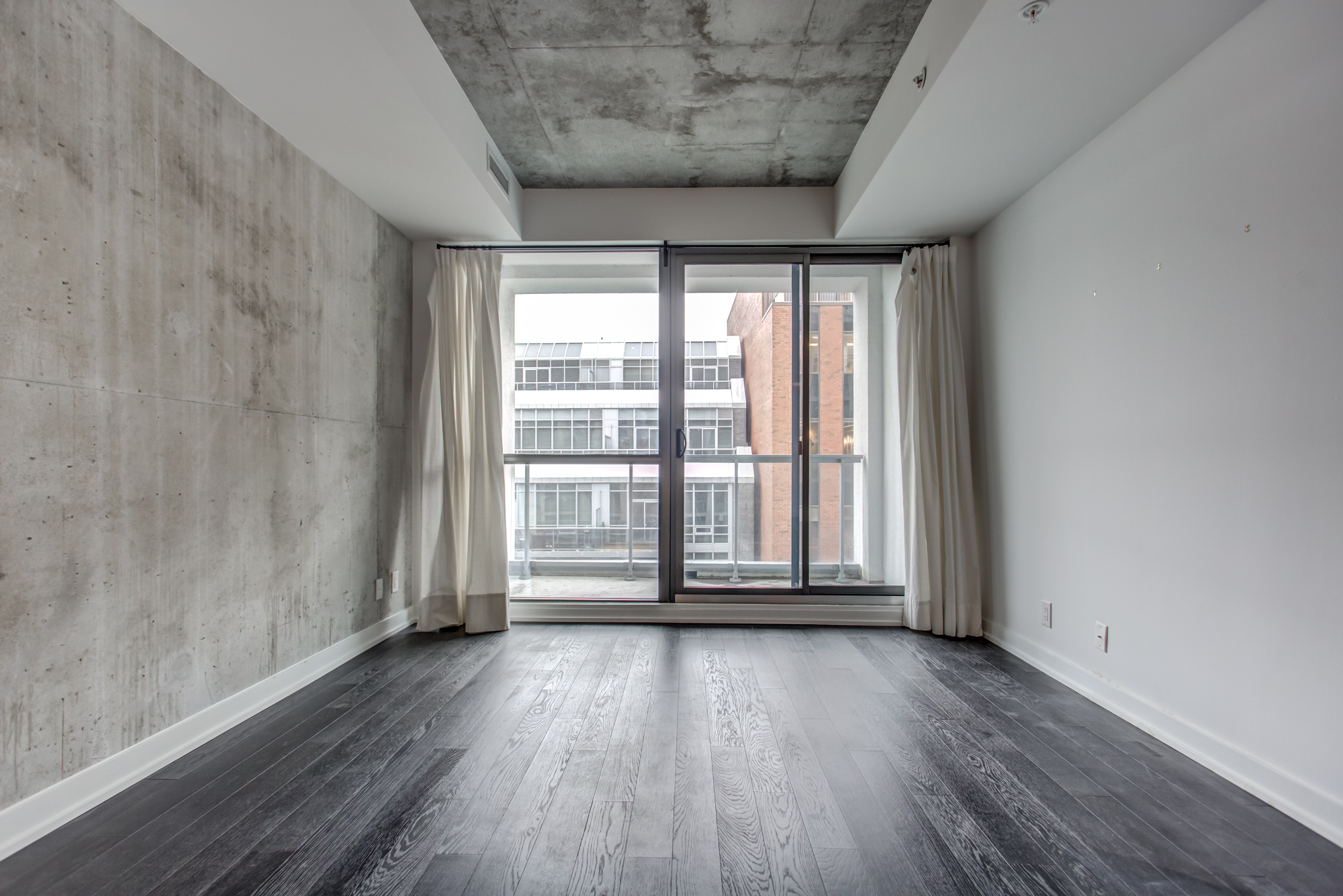 Industrial-style loft with unfinished wall and ceiling on 39 Brant St Unit 918 in Queen West, Brant Park Lofts.