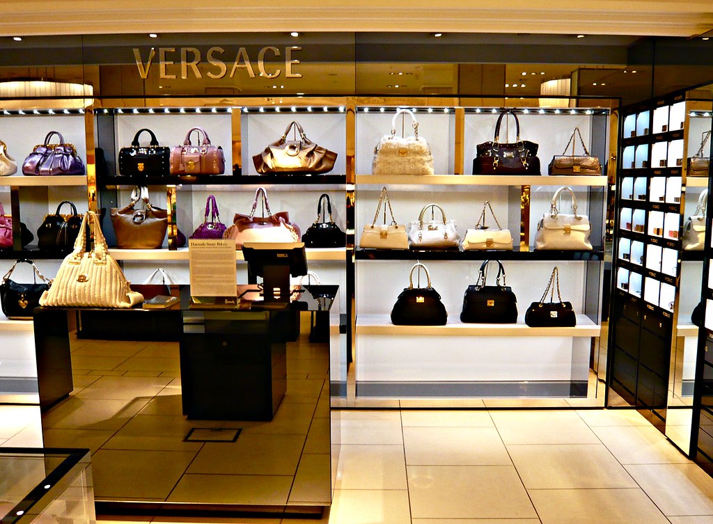 Versace store with designer hand bags on display shelves.