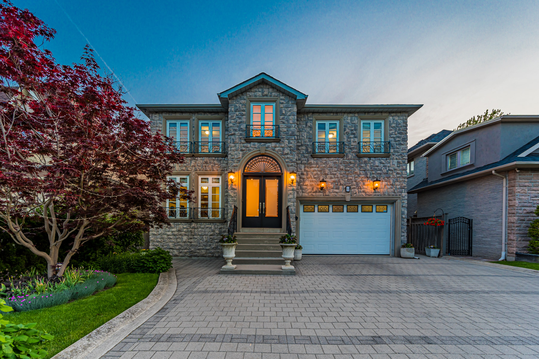 Evening photo of 12 Highland Hill, detached 2-storey house, with orange lights.